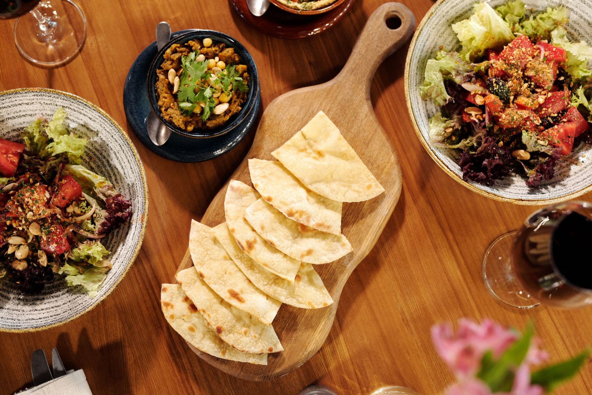 Uppdukat grekiskt bord med pitabröd, sallader och meze